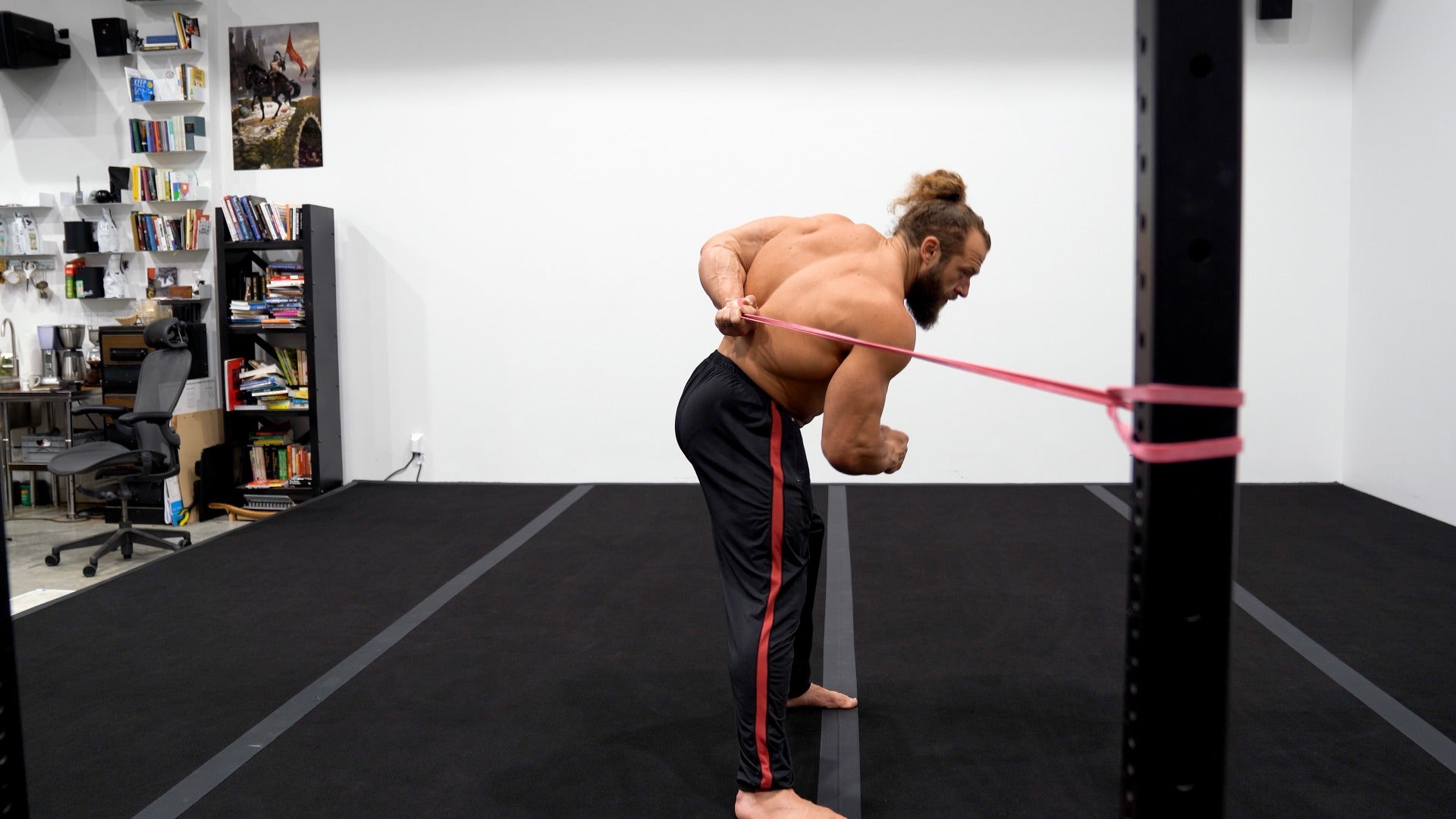Man exercising with resistance bands in a home office setting