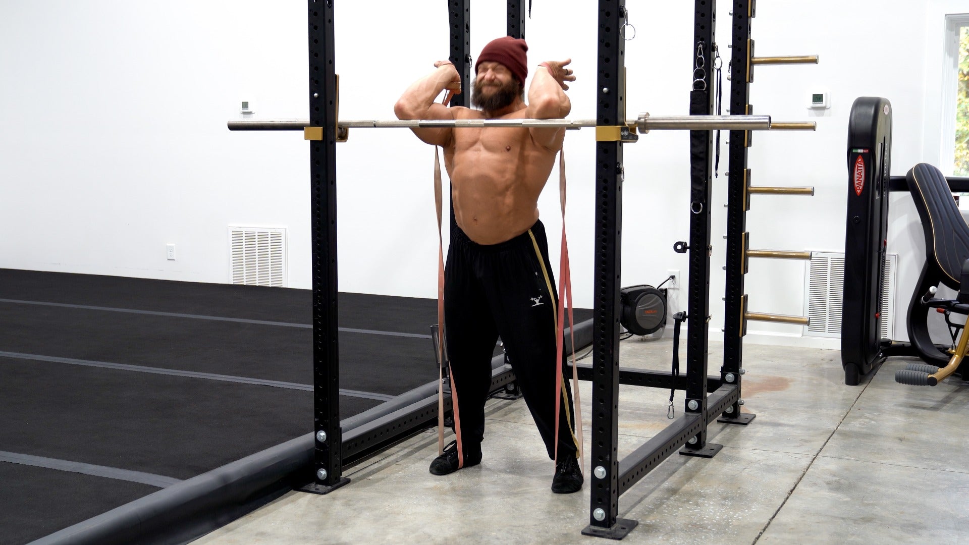 Man performing a pull-up exercise in a home gym setting.
