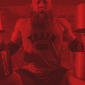 Person wearing a 'TRAIN' t-shirt in a gym setting with red filter.